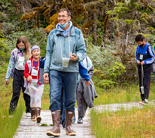 Students and an educator walking along a forest trail