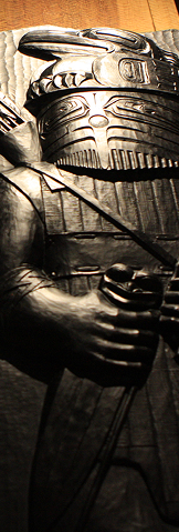 Dark glass house post depicting a Raven warrior