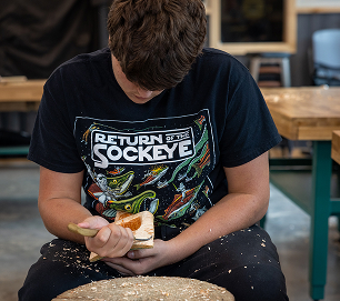 A student carving a wooden bowl during Atnané Academy