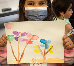 A student holding a colorful painting
