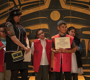 A TCLL student holding a certificate during a recognition ceremony